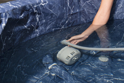 Water powered vacuum attached to hot tub