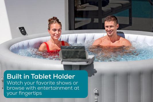 Couple relaxing in hot tub watching tablet on accessory tray